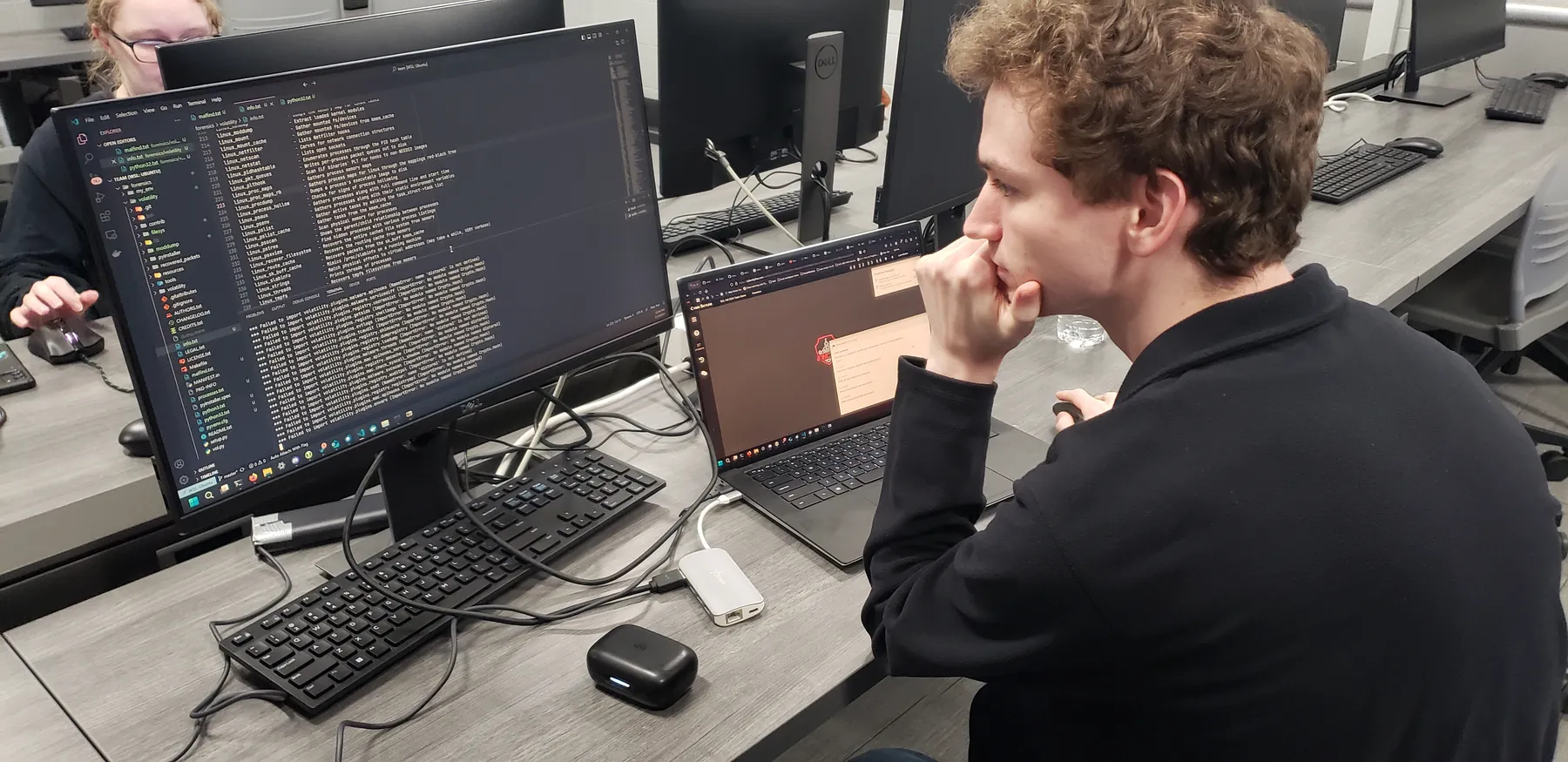 Student working through cybersecurity challenges at a computer station during an NCL competition