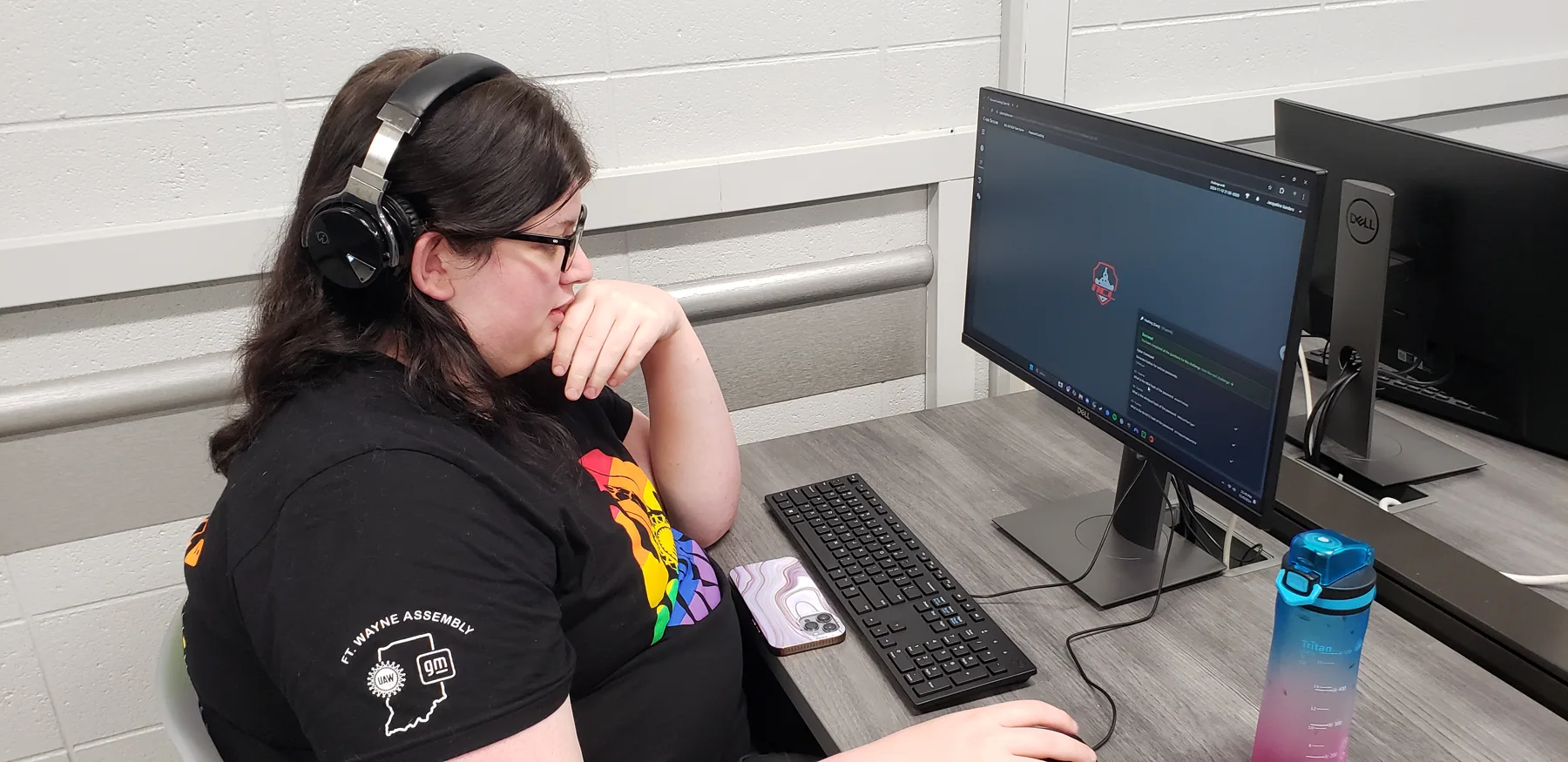 Student wearing headphones working at a computer during cybersecurity competition activity