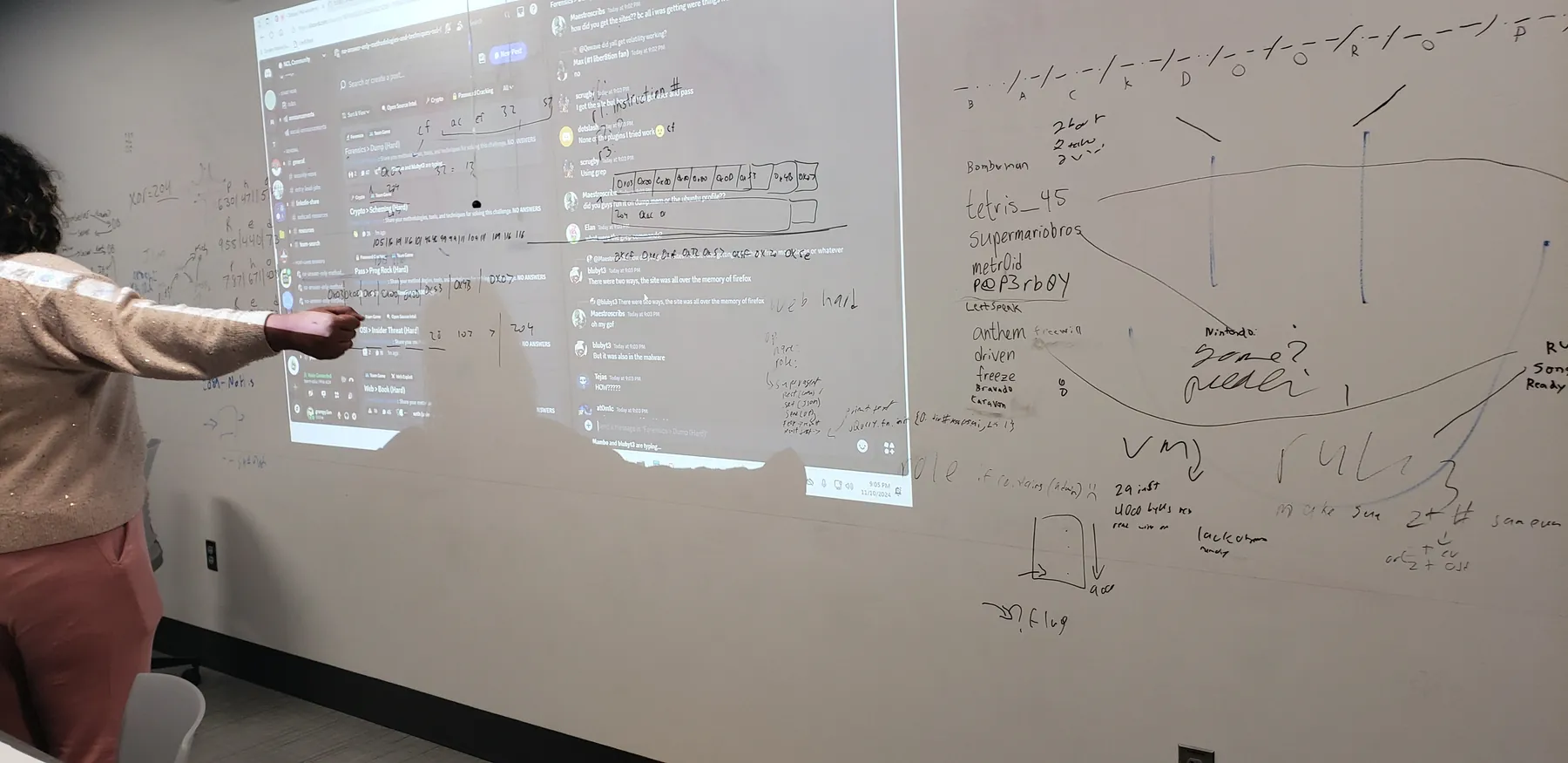 Shared screen and whiteboard covered with challenge notes during a cybersecurity event